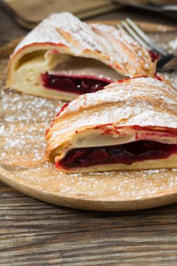 Ahşap arka plan üzerinde kiraz ile Strudel. Rustik stil