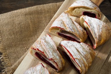 Ahşap arka plan üzerinde kiraz ile Strudel. Rustik stil