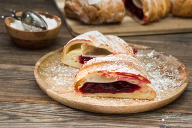 Ahşap arka plan üzerinde kiraz ile Strudel. Rustik stil