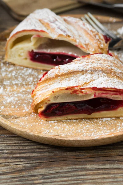 Ahşap arka plan üzerinde kiraz ile Strudel. Rustik stil