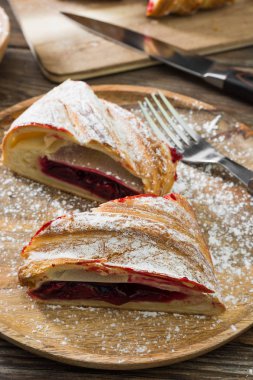 Ahşap arka plan üzerinde kiraz ile Strudel. Rustik stil