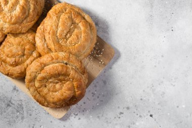 Açık gri mutfak masasında tahta tahtada çörekler. Üst görünüm