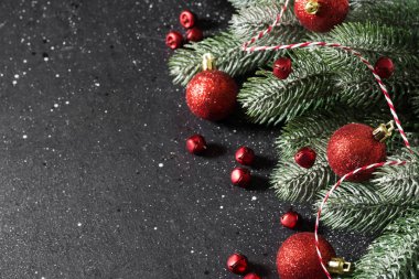 Christmas or New year holiday background with fir branches and red decorations. Top view with copy space