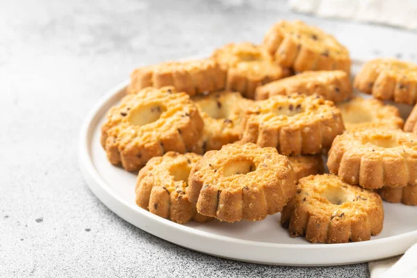 Işık masasında beyaz seramik tabakta çörekler. Mutfak masasında bir tabak kurabiye. Kurabiyeler kapanıyor.