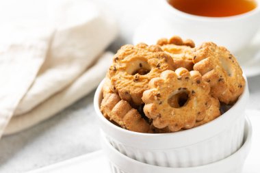Işık masasında beyaz seramik tabakta çörekler. Mutfak masasında bir tabak kurabiye. Kurabiyeler kapanıyor.
