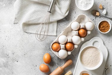 Mutfak zemininde pişirmek için gerekli malzemeler. Yumurta, un, tarçın, şeker, mutfak masasında soda. Pişirme hazırlığı kavramı