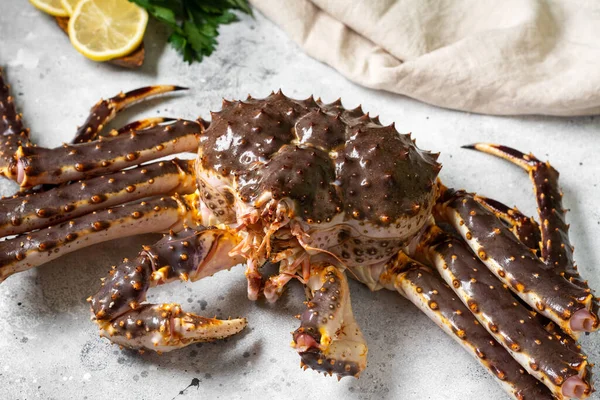 Kamçatka yengeci. Mutfak masasında çiğ yengeç var. Kamçatka yengeci masada. Yemek pişirme süreci