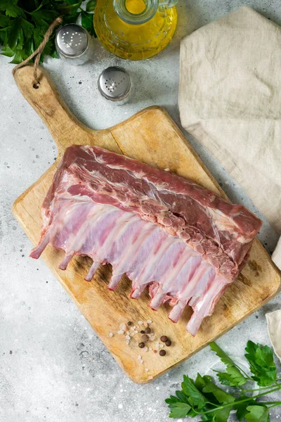 Lamb meat. Lamb ribs on a wooden chopping Board on the light gray kitchen table. Raw lamb meat on the table, loin