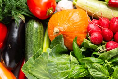 Sebze çeşitleri masanın üzerinde. Turp, patlıcan, balkabağı, lahana, biber, soğan ve bitkiler masada. Sağlıklı beslenme kavramı. Sonbahar hasadı. Üst görünüm