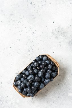 Hafif arka planda ahşap bir kutuda yabanmersini. Kutuda taze yaban mersini. Metin için boşluk olan üst görünüm
