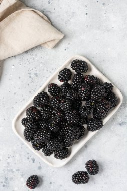 Böğürtlen Arka planda beyaz bir tabakta böğürtlen. Kasede taze böğürtlen. Metin için boşluk olan üst görünüm
