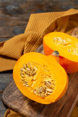 Hokkaido Balkabağı. Kahverengi ahşap bir masada dilimlenmiş bir balkabağı. Balkabakları yakın plan. Sonbahar hasadı konsepti