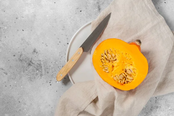 Hokkaido Pumpkin. Sliced pumpkin in a white plate on a light gray table. Top view with space for text