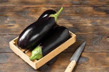 Patlıcan. Kahverengi ahşap bir masada, tahta bir kutuda patlıcan.