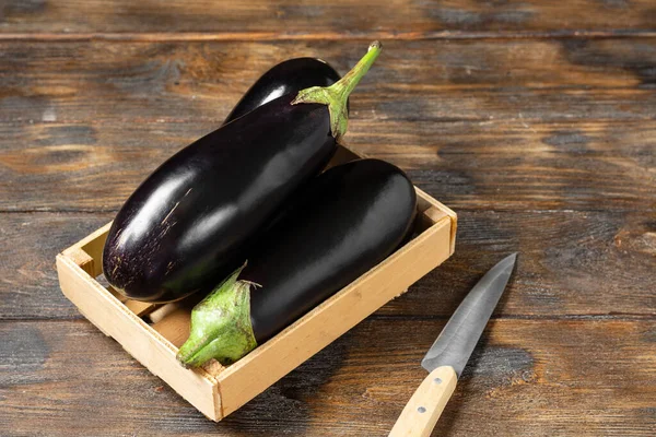 Patlıcan. Kahverengi ahşap bir masada, tahta bir kutuda patlıcan.