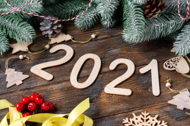 Mutlu yıllar 2021. Tahta Noel ya da Noel ağacı dallarında yeni yıl süslemeleri. Ahşap numaraları 2021 olan Noel arkaplanı