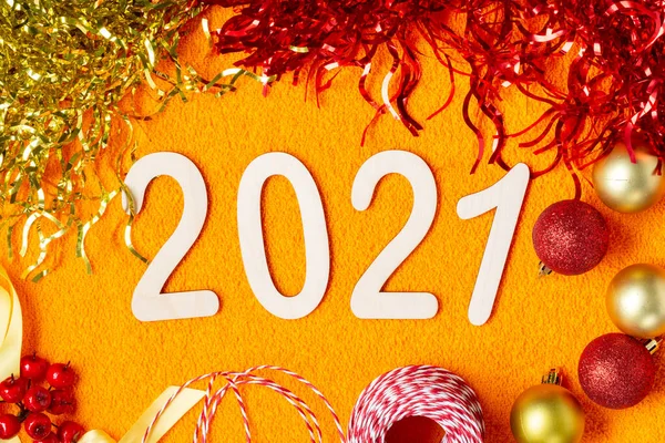 Happy new year 2021. Christmas or new year decorations on an orange background. Christmas background with wooden numbers 2021