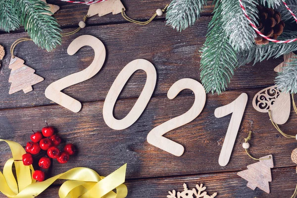 Mutlu yıllar 2021. Tahta Noel ya da Noel ağacı dallarında yeni yıl süslemeleri. Ahşap numaraları 2021 olan Noel arkaplanı