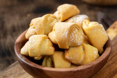 Bir sürü simit. Kahverengi bir masada, ahşap bir tabakta puf böreği. Kurabiyeler kapanıyor.