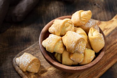  Bir sürü simit. Kahverengi bir masada, ahşap bir tabakta puf böreği. Kurabiyeler kapanıyor.