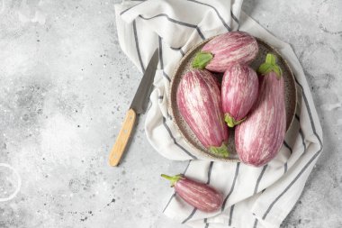 Patlıcan. Açık gri bir masada seramik tabakta patlıcan. Metin için boşluk olan üst görünüm