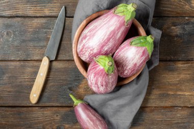 Patlıcan. Kahverengi ahşap bir masada, tahta bir kasede patlıcan. Yukarıdan görünüşü