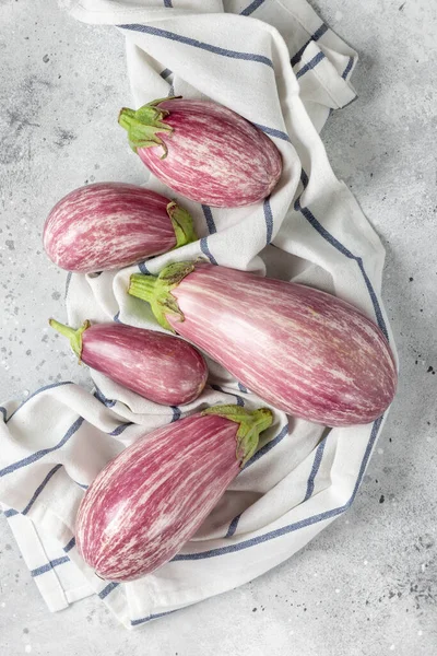 Patlıcan. Patlıcanlar açık gri bir masaya yayılır. Metin için boşluk olan üst görünüm