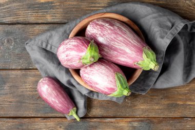 Patlıcan. Kahverengi ahşap bir masada, tahta bir kasede patlıcan. Yukarıdan görünüşü