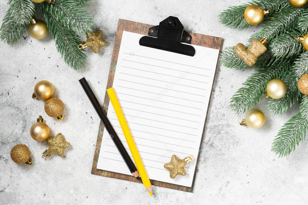 Christmas or New year holiday background with an open blank Notepad, spruce branches and traditional Christmas decorations. A checklist or a letter to Santa. Top view with copyspace