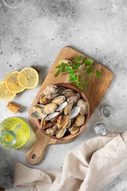 Açık gri bir masada ahşap bir kasede kaynamış midyeler. Deniz kabukluları yakın plan. Deniz ürünleri tabağı. Metin için boşluk olan üst görünüm