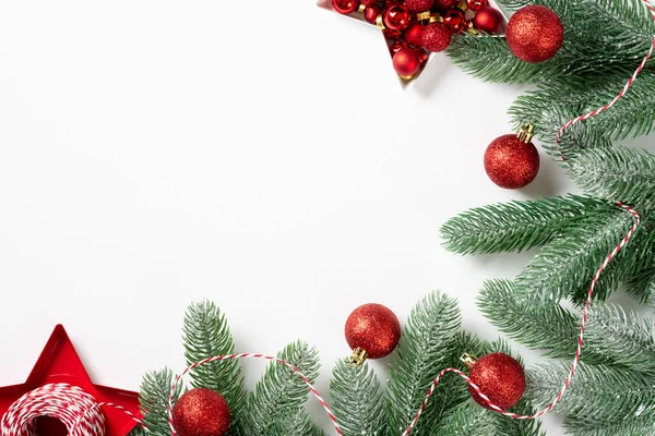 Christmas background. Red decorations on spruce branches on a white background. Christmas Flatly. Top view from copyspace