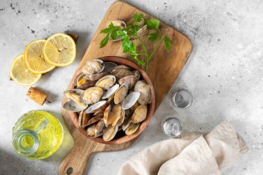 Açık gri bir masada ahşap bir kasede kaynamış midyeler. Deniz kabukluları yakın plan. Deniz ürünleri tabağı. Metin için boşluk olan üst görünüm