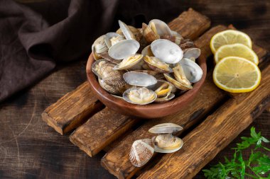 Kahverengi ahşap bir masada ahşap bir kasede kaynamış midyeler. Kabuklu deniz hayvanları yakın plan.