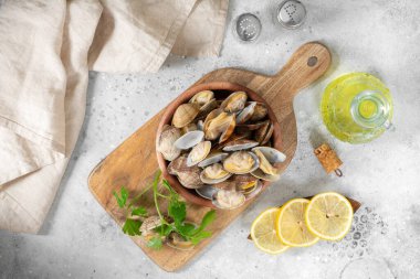 Açık gri bir masada ahşap bir kasede kaynamış midyeler. Deniz kabukluları yakın plan. Deniz ürünleri tabağı. Metin için boşluk olan üst görünüm