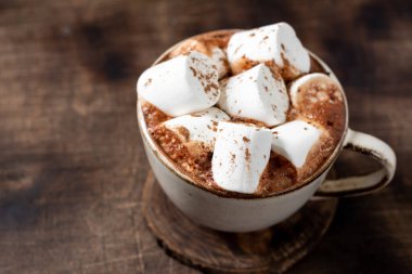 Sıcak kakao ya da kahverengi ahşap bir masada seramik bir kupada lokum kaplı sıcak çikolata.