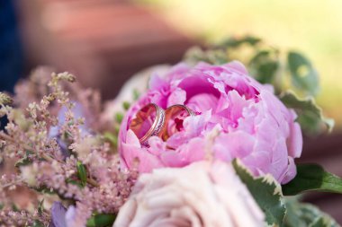 Gelin elinde bir buket çiçek tutuyor.