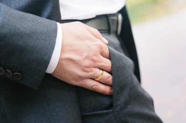 Siyah takım elbiseli damat, elleri yakın çekim.