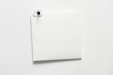 Kare beyaz kağıt çarşaf düğmeli bir duvarda. Harf üst görünümü. Kağıt zarf şablonlu boş kart