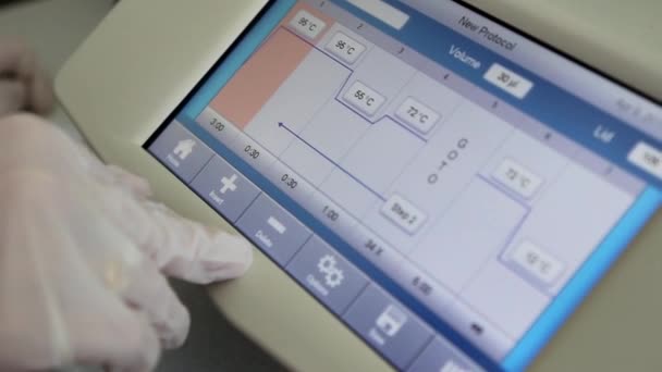 Scienziato con mano guantata sta programmando l'analisi del DNA in tempo reale PCR-cycler — Video Stock