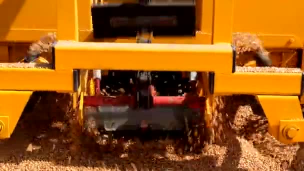 Схватывание зерна с поверхности асфальта скребками конвейерного зернопогрузчика — стоковое видео