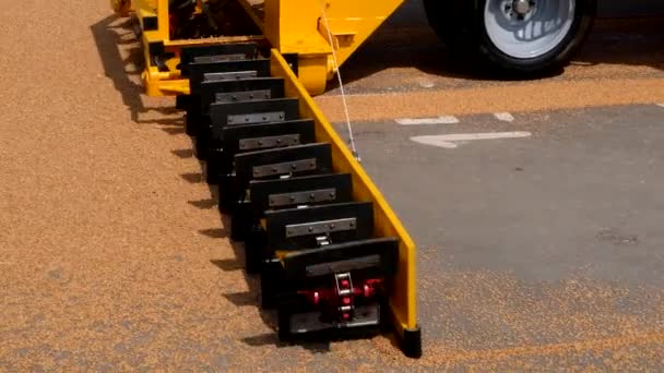 Grijpen graan uit asfalt oppervlak door schrapers van transportband graan loader — Stockvideo
