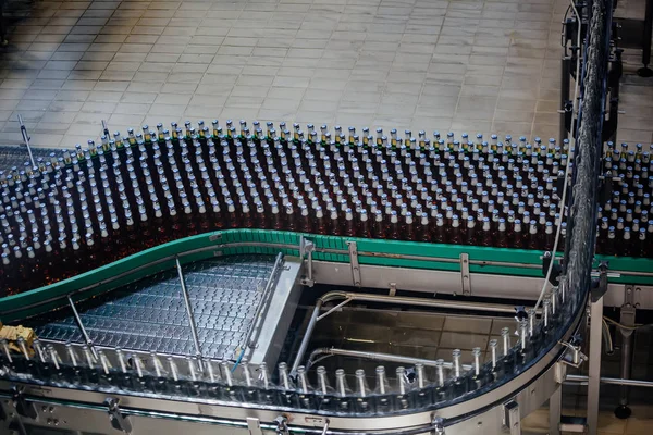 Bierflessen verplaatsen op transportband, close-up — Stockfoto