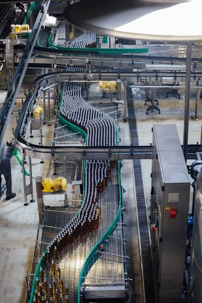 Moderne geautomatiseerde bier bottelen productielijn. Bierflessen verplaatsen op transportband — Stockfoto