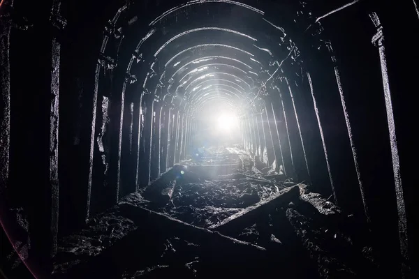 Ciemna opuszczona kopalnia węgla z zardzewiałe podszewka w podświetlenie — Zdjęcie stockowe