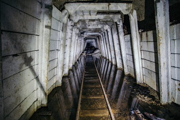 Flooded abandoned uranium mine with rusty railway
