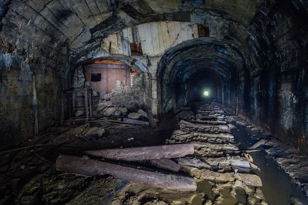 Dark abandoned coal mine with rusty remnants of equipment — Stock Photo, Image