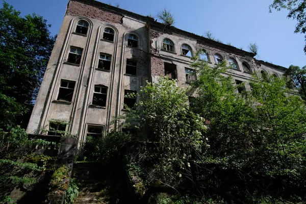 Ruined overgrown school in ghost mining town, consequences of war in Abkhazia, green post-apocalyptic concept — Stock fotografie