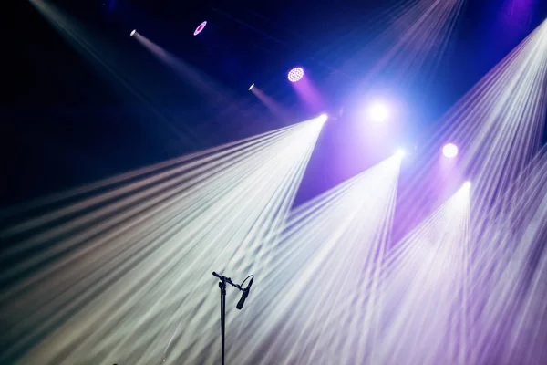 Microfone e raios brilhantes de luz no palco antes do concerto começar — Fotografia de Stock