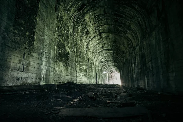 Luz al final del túnel ferroviario abandonado. Ferrocarril cubierto — Foto de Stock