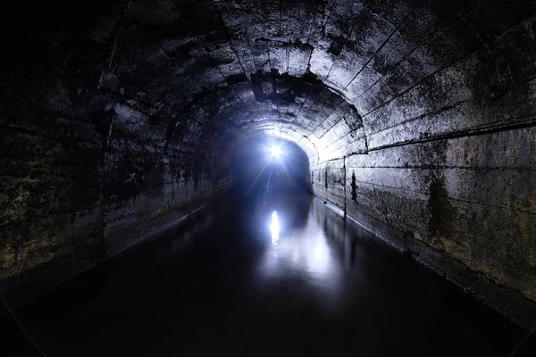 Túnel de la mina de drenaje abovedado de hormigón inundado oscuro — Foto de Stock